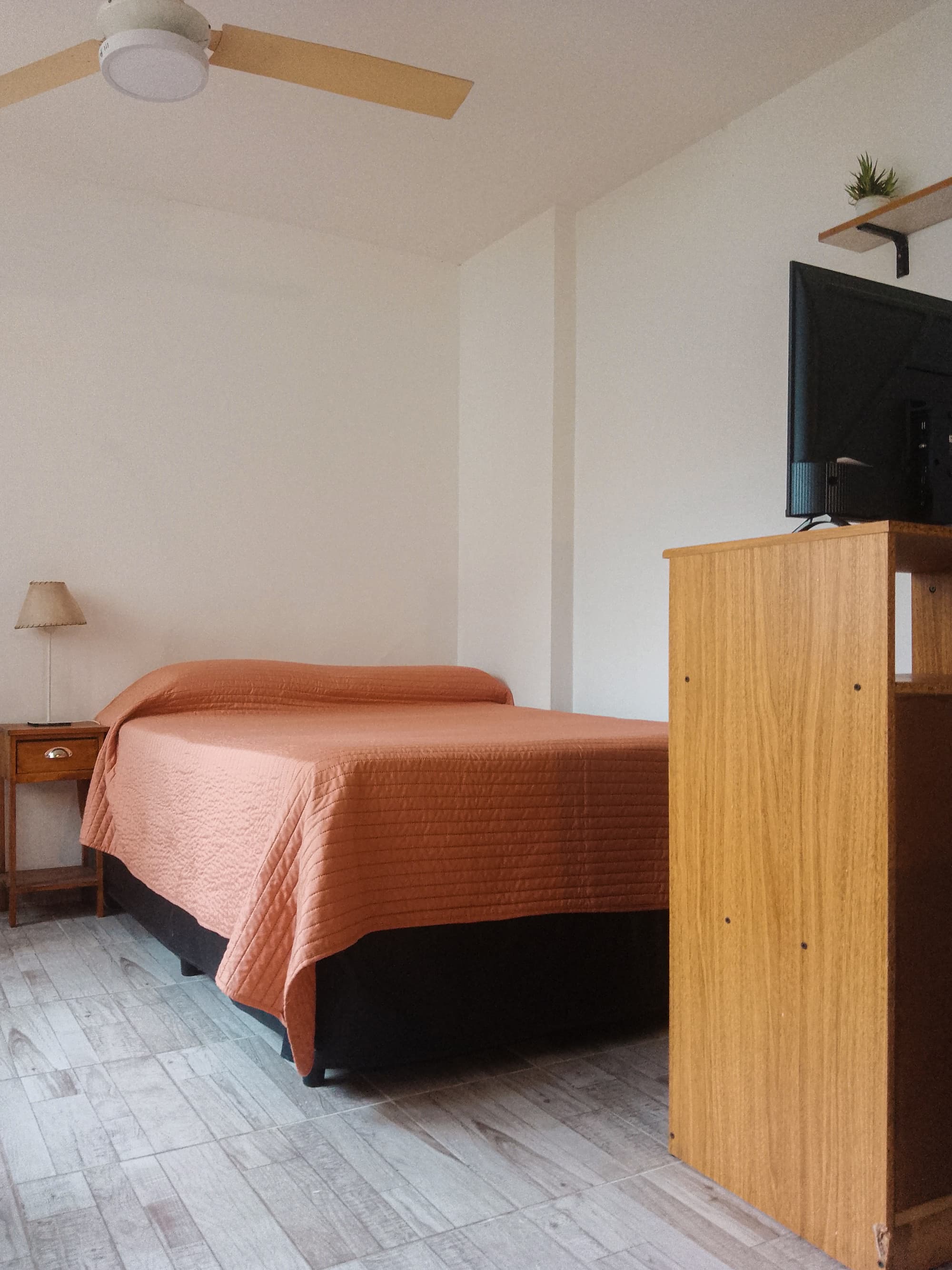 Cama doble con sábanas blancas y toallas